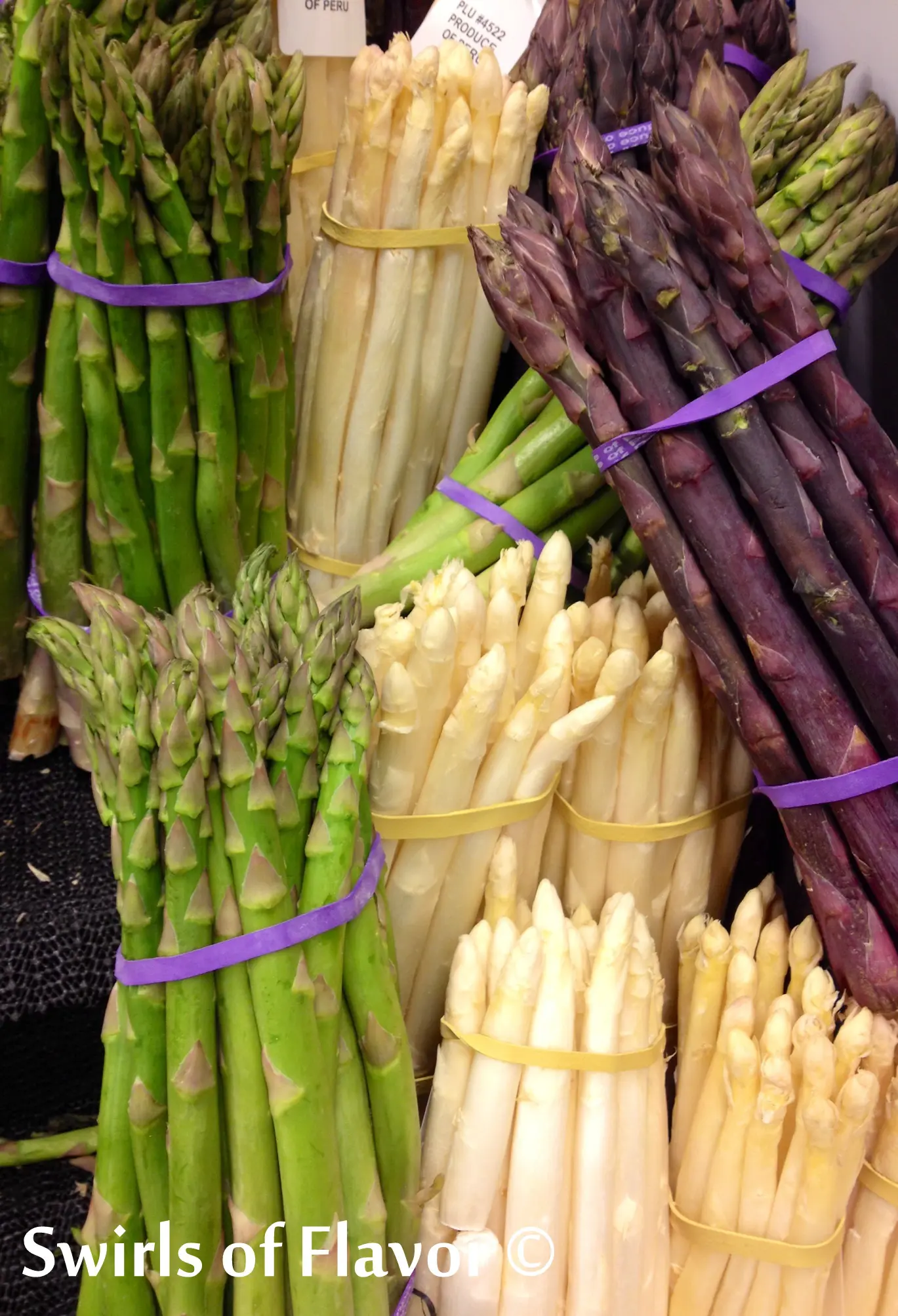 bunched of fresh asparagus in green, white and purple