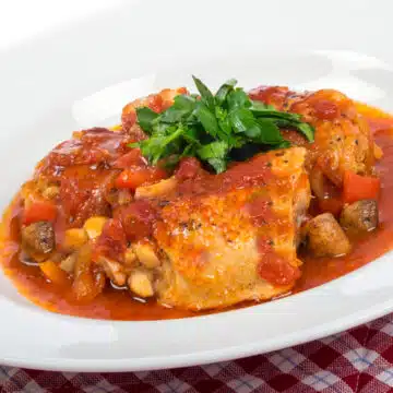 chicken with tomato sauce in a white dish