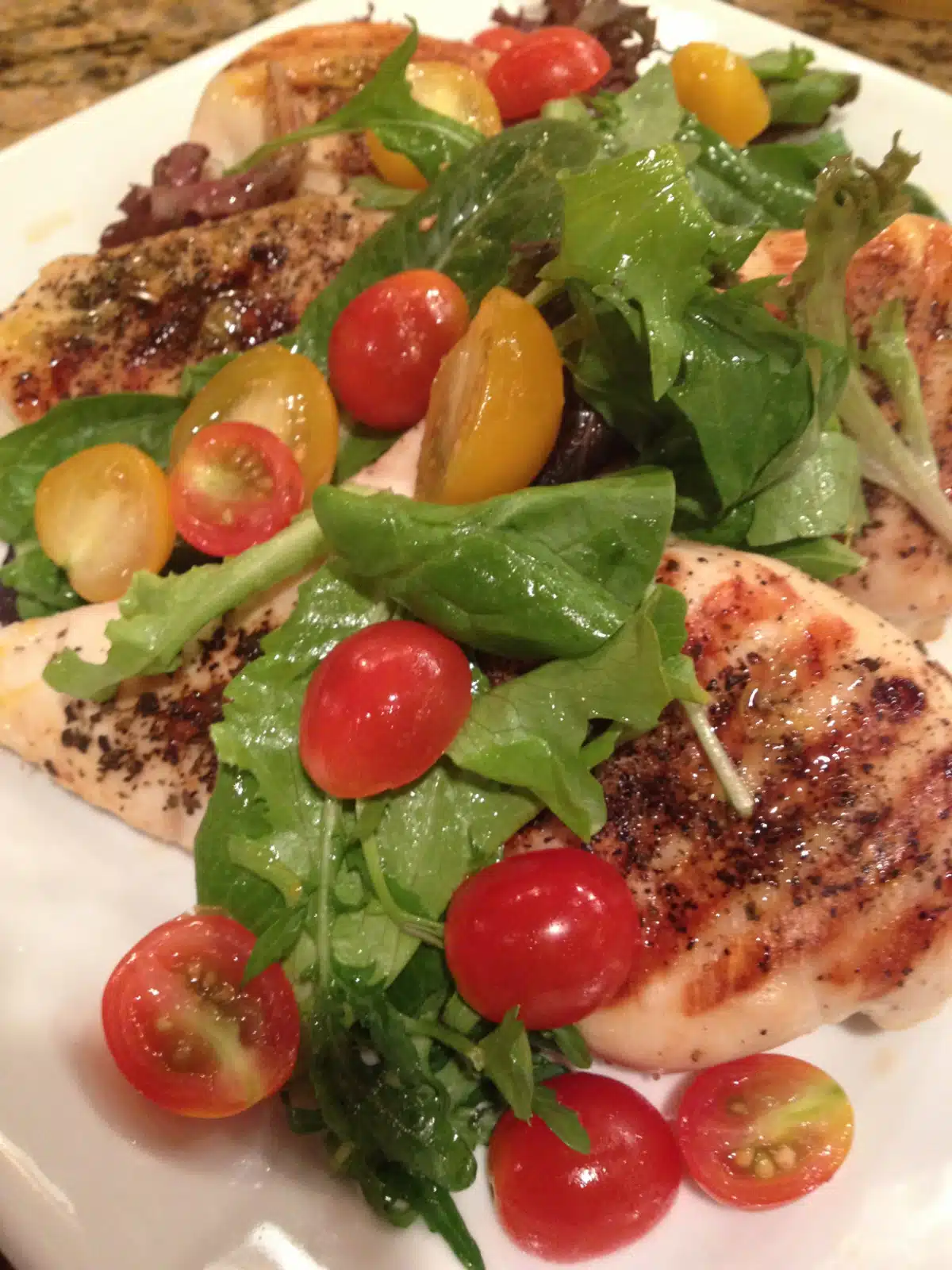 grilled chicken milanese topped with a tossed salad