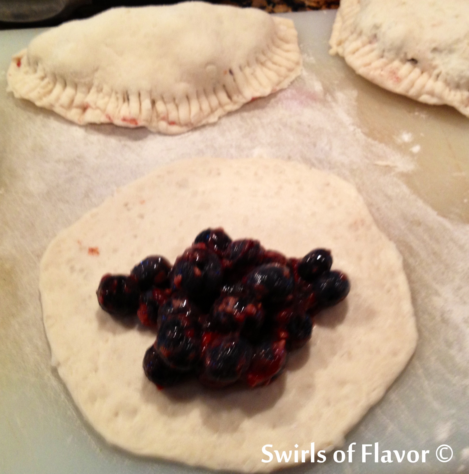 Unbaked Blueberry hand pies with filling in center