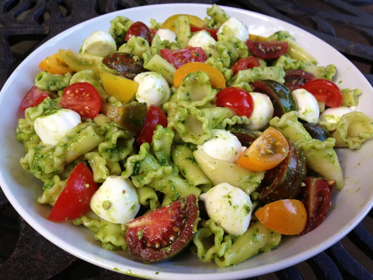pesto pasta salad with tomatoes in a bowl