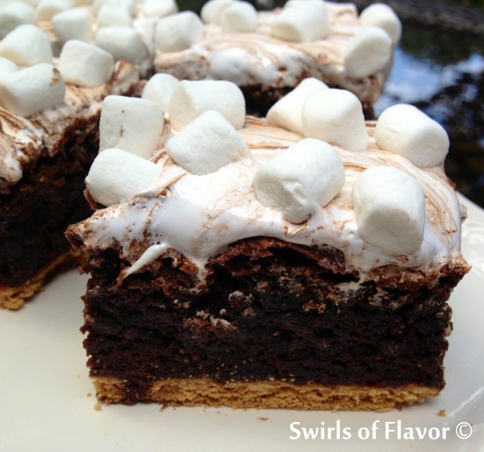 Gooey S'mores Brownies is an easy recipe that takes s'mores to another level. Graham crackers are baked into brownies and then topped with chocolate bars and marshmallow fluff creating a melty gooey chocolate marshmallow topping with mini marshmallows on top! #brownies #s'mores #baked #dessert #funforkids #marshmallows #grahamcrackers #swirlsofflavor