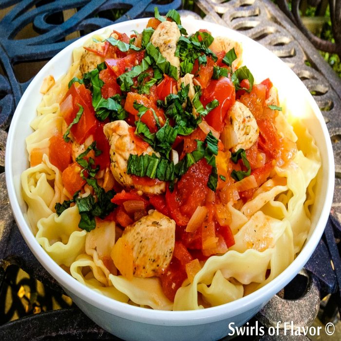 chicken pomodoro with pasta in a white bowl