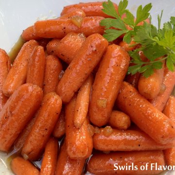 Gingered Cinnamon Honey Glazed Carrots are an easy recipe for a weeknight dinner or entertaining. Carrots are simmered in honey with a hint of cinnamon and crystallized ginger for a side dish you'll want to make over and over again!