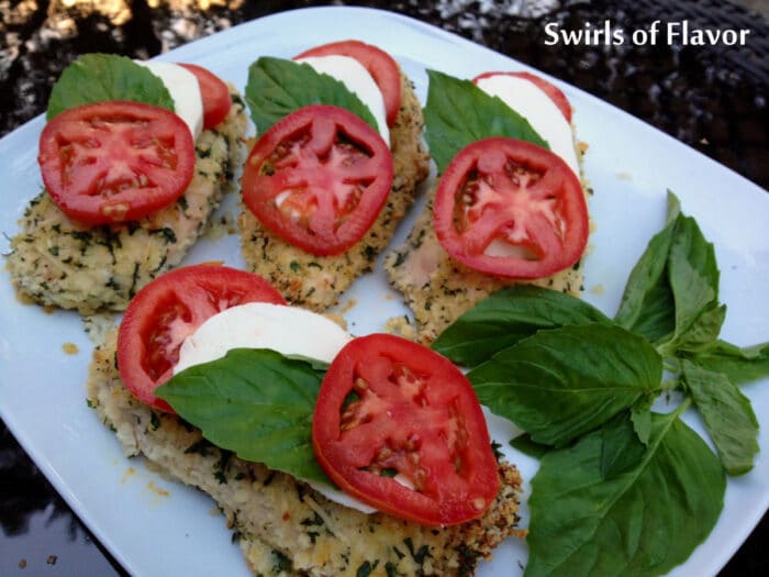 chicken caprese on a platter with fresh basil sprig