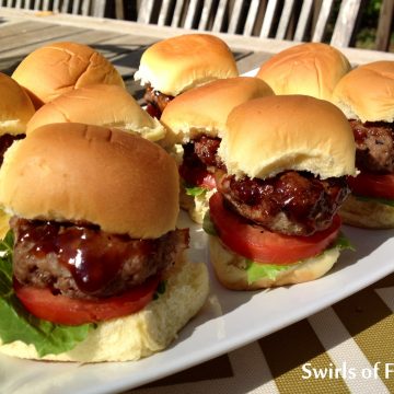 Bourbon Glazed Bacon Sliders have bits of bacon in the burger. Barbecue sauce with bourbon glazes over on the sliders making every bite flavorful and saucy. Our homemade beef burger sliders with bacon can be grilled or cooked stove top and will be the hit of every get together! #beef #beefburgers #bacon #baconburgers #bourbon #bourbonglaze #sliders #baconsliders #partyfood #gamedayfood #grilling #swirlsofflavor