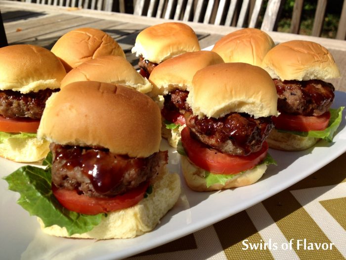 Bourbon Glazed Bacon Sliders have bits of bacon in the burger. Barbecue sauce with bourbon glazes over on the sliders making every bite flavorful and saucy. Our homemade beef burger sliders with bacon can be grilled or cooked stove top and will be the hit of every get together! #beef #beefburgers #bacon #baconburgers #bourbon #bourbonglaze #sliders #baconsliders #partyfood #gamedayfood #grilling #swirlsofflavor