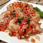 Bruschetta Pork Chops is an easy dinner recipe for sauteed pork chops with a buttery tomato and garlic topping swirled with a touch of balsamic vinegar and fresh basil.