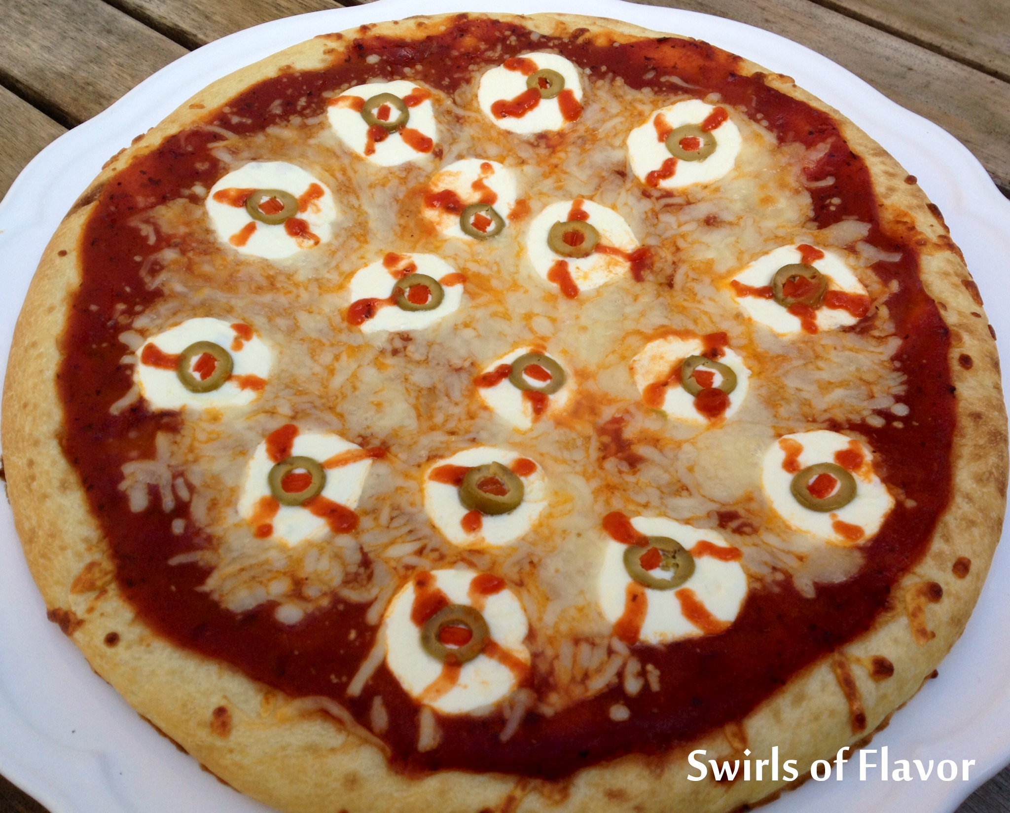 Halloween pizza with olive and cheese eyeballs 