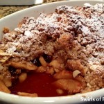 Oatmeal cookie topped apple crisp in baking dish with scoop out