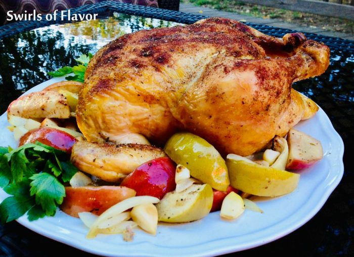 roasted chicken with apples and onions on a white platter