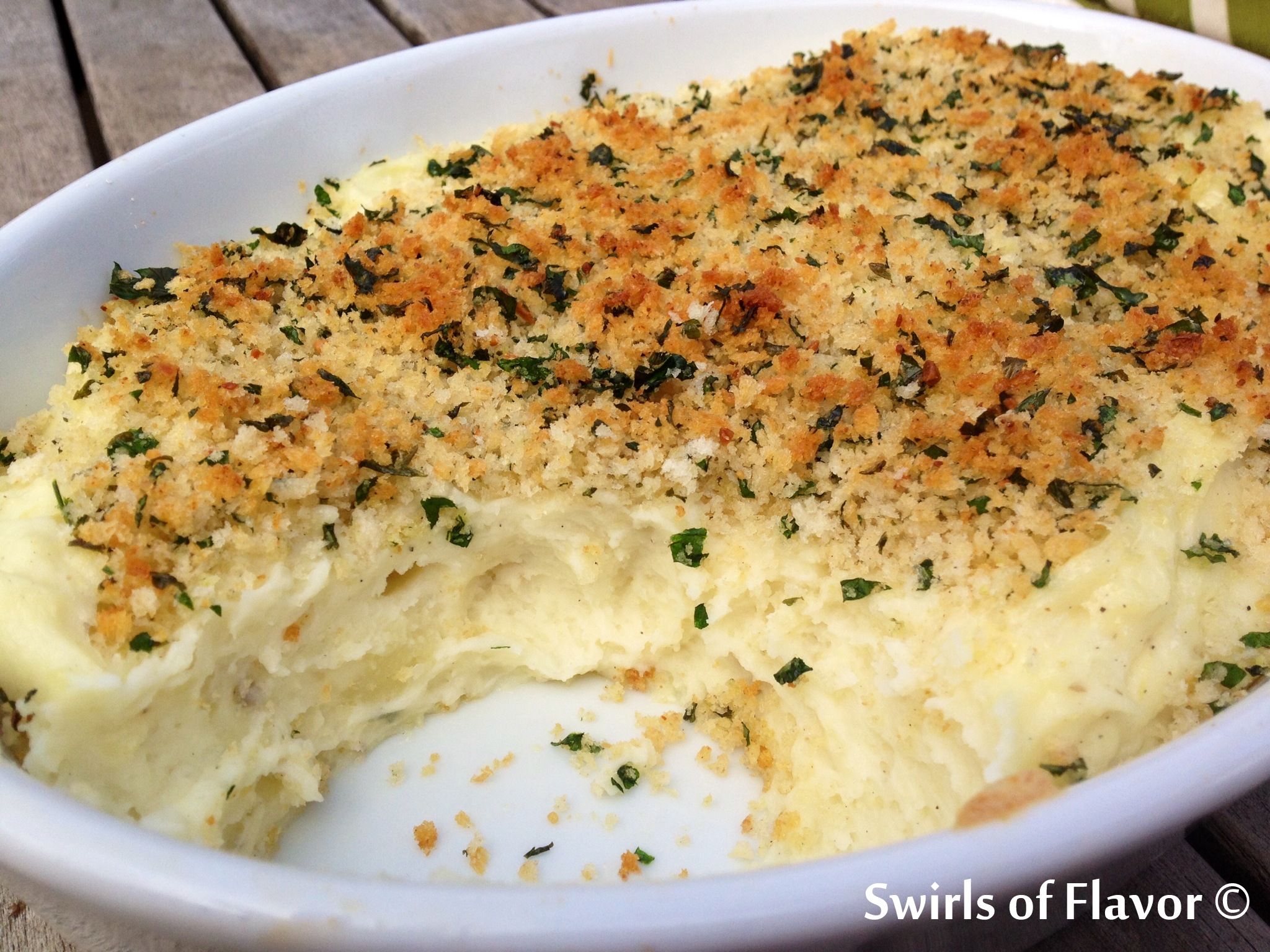 Panko Garlic Mashed Potatoes in baking dish with scoop out