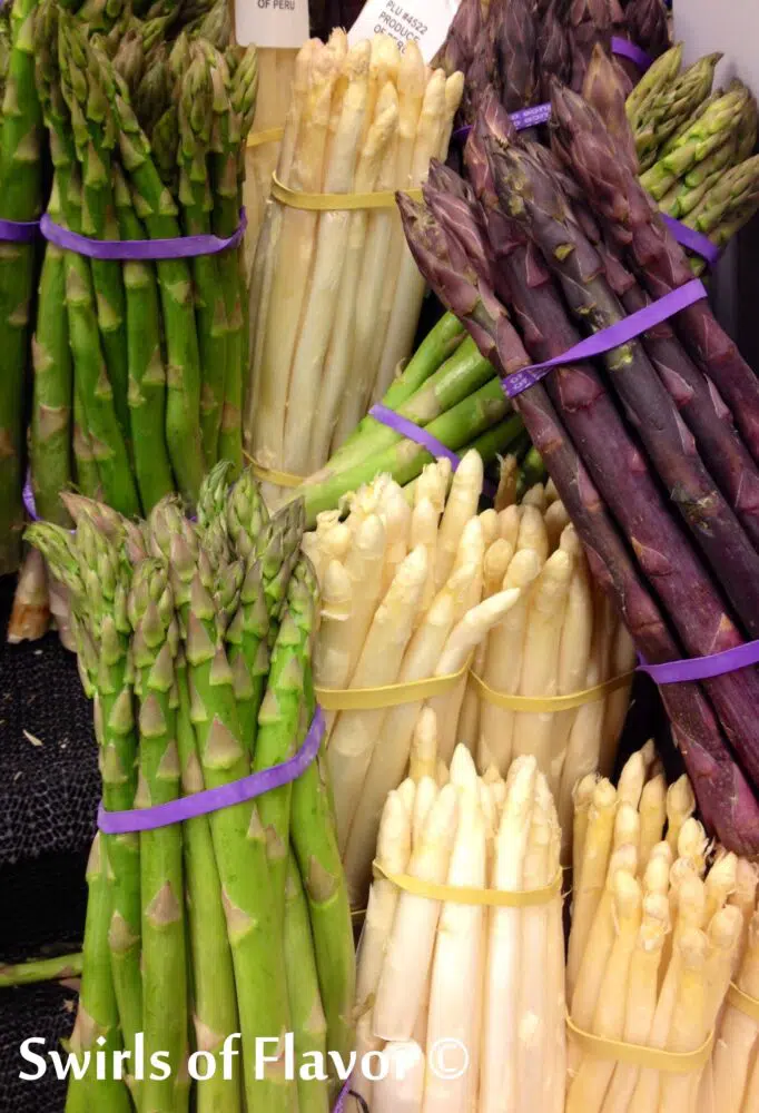 bunches of green, white and purple asparagus