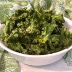baked kale chips in a bowl with green print napkin