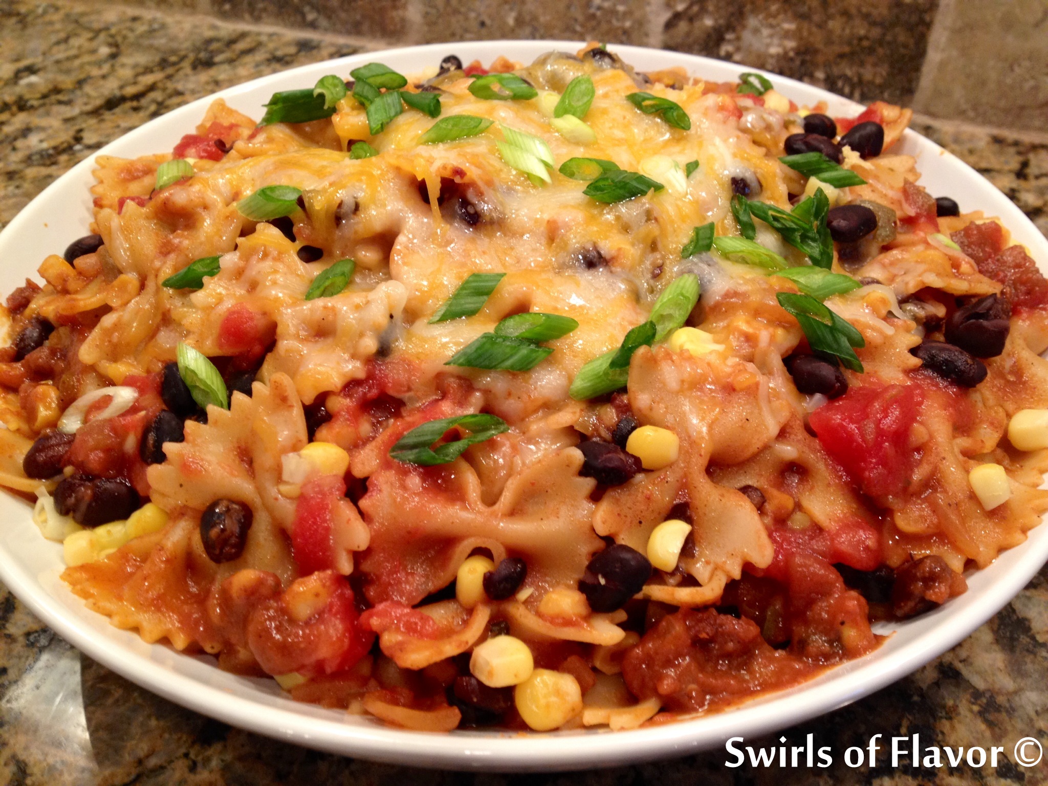 One Pot Mexicali Bowtie Pasta, an easy weeknight recipe that cooks in just minutes in one pot, is bursting with corn, black beans, pasta and cheesiness! recipe | easy | dinner | one pot | pasta | corn | black beans | mexican | #swirlsofflavor