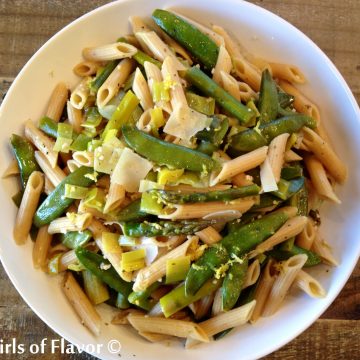 Penne and spring vegetables in a white bowl