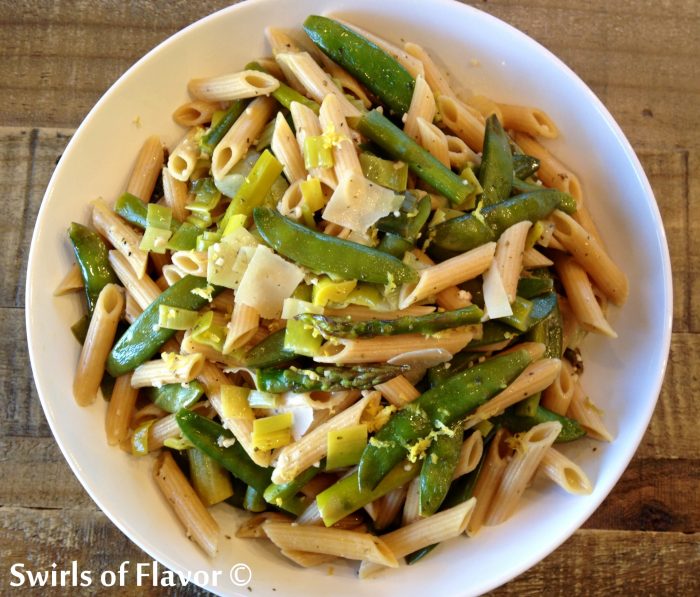 Penne and spring vegetables in a white bowl