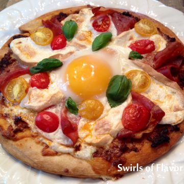 Smoked Mozzarella & Prosciutto Breakfast Pizzas are made with store bought pizza crusts topped with pesto, prosciutto, smoked mozzarella and tomatoes, then with an egg. and baked in the oven!