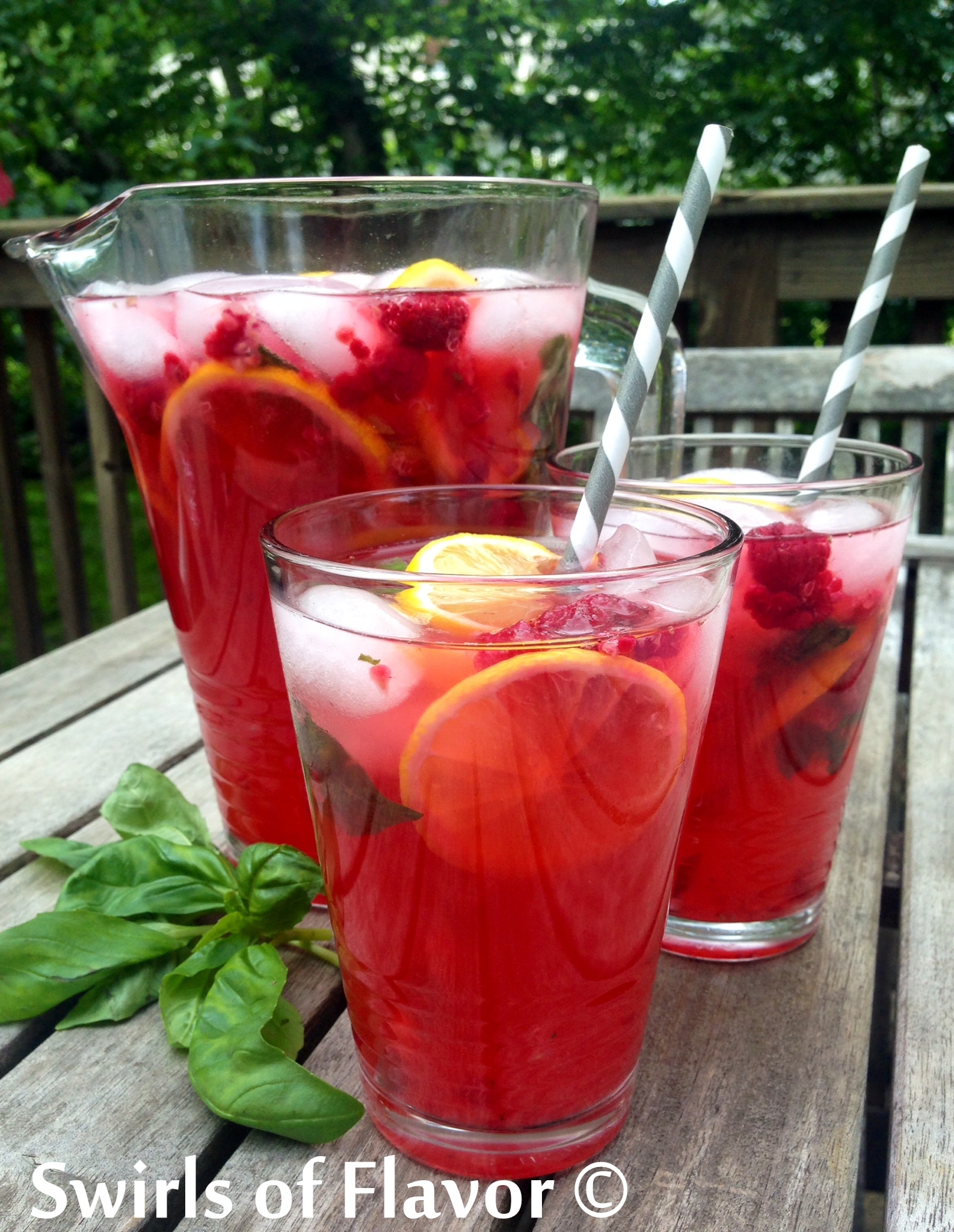 Raspberry Basil Lemonade in a itcher and two glasses