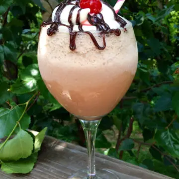 kahlua mudslide drink in tall wine glass with cherry on top