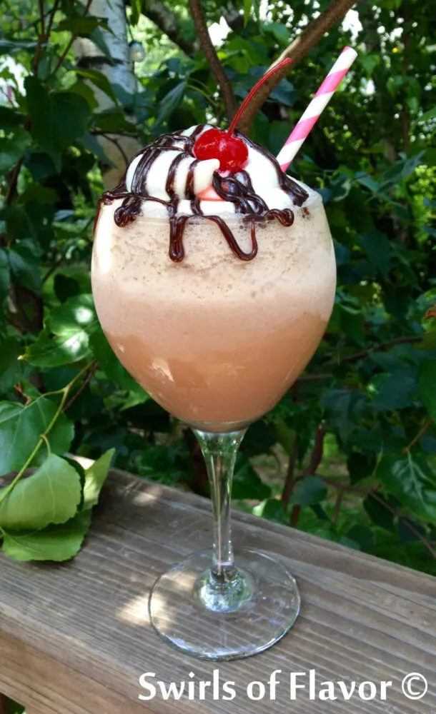 kahlua mudslide drink in tall wine glass with cherry on top