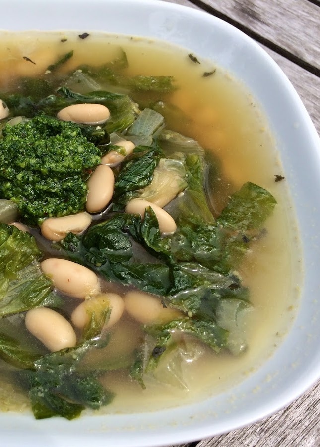 half bowl of soup with greens and beans