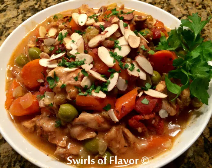 Moroccan chicken with almonds and parsley in a white bowl
