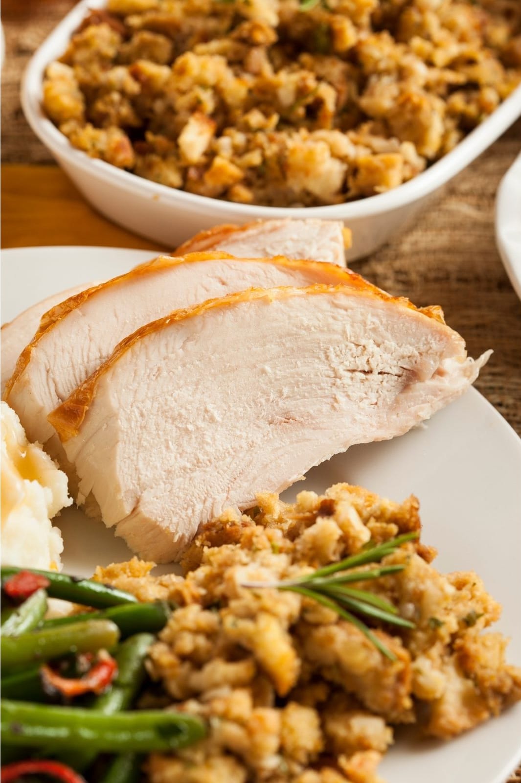 sliced turkey with stuffing on a white plate