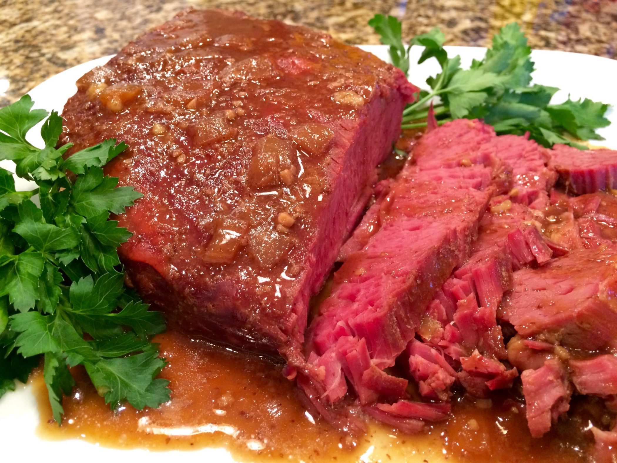 slow cooker corned beef with Guinness sliced and with sauce and fresh parsley