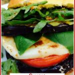 caprese eggplant sandwich on a roll with text overlay