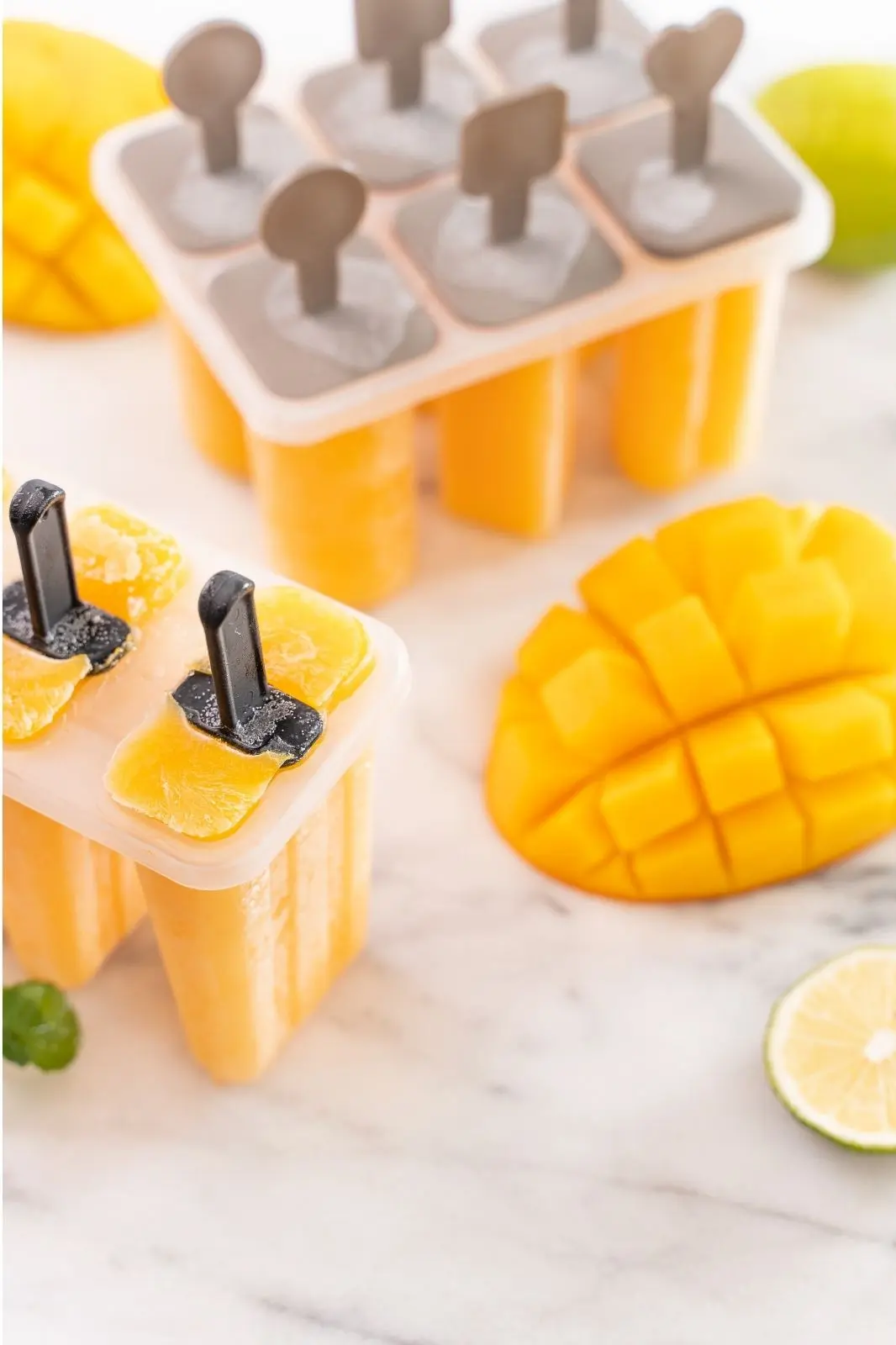 mango ice pops in mold with fresh mango