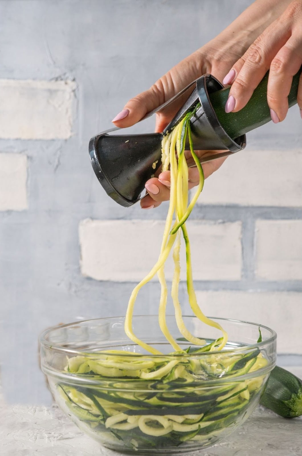 making zucchini noodles with a handheld spiralizer