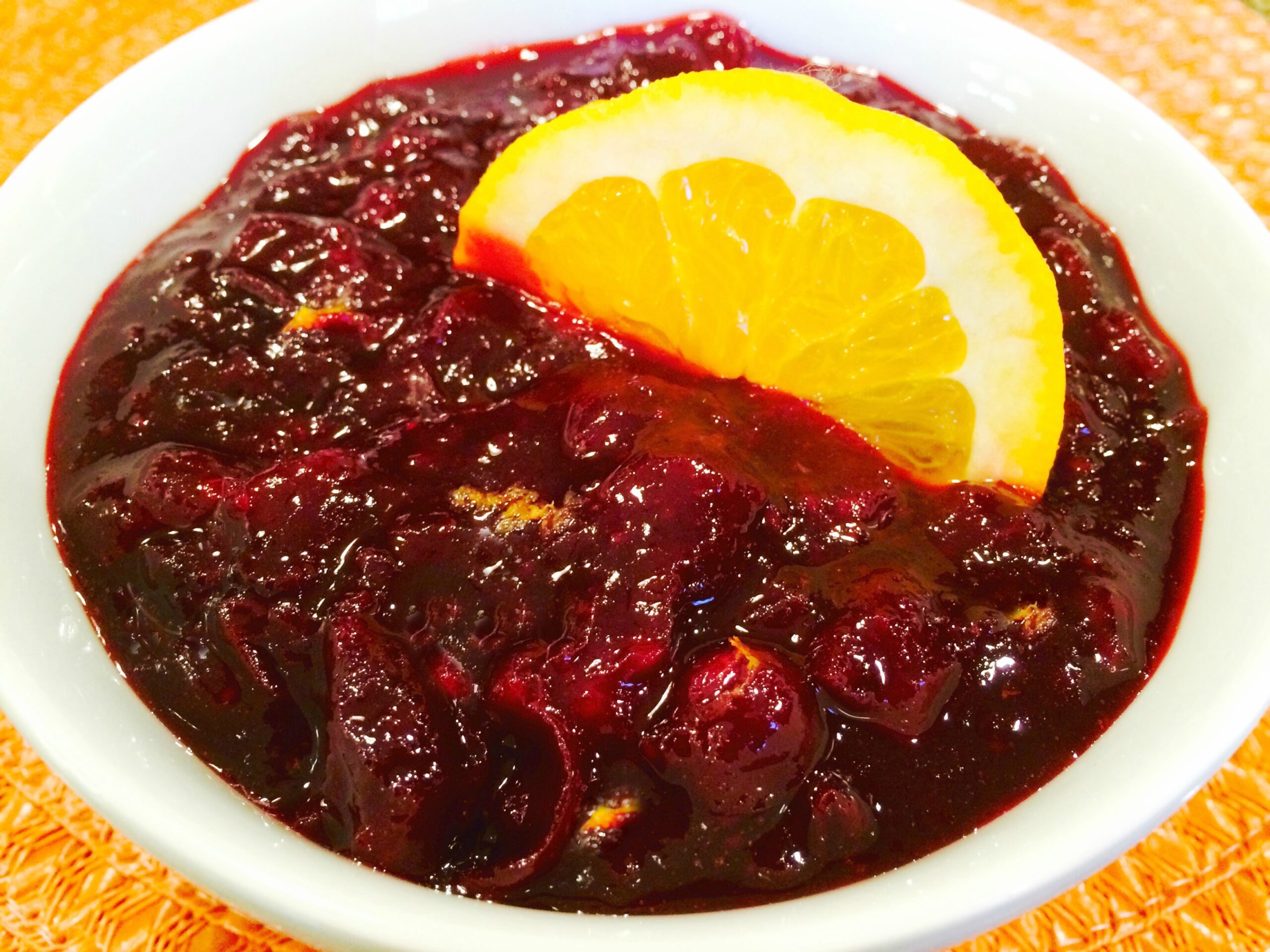 bowl of homemade cranberry sauce with slice of orange
