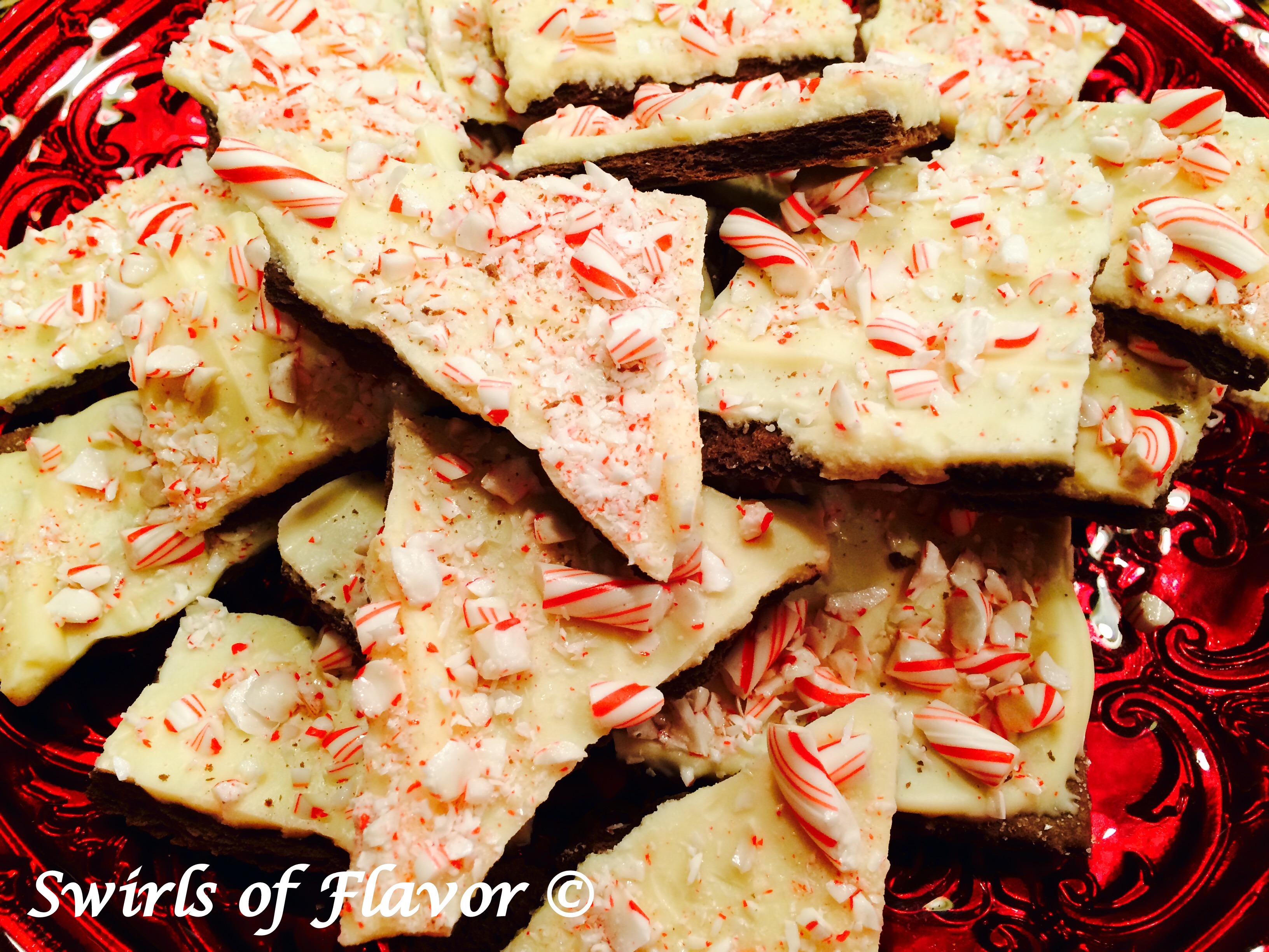 No-Bake Peppermint Bark Cookies....a twist on a holiday favorite! White chocolate surrounded by peppermint candy and chocolate cookies are guaranteed to be a hit on your holiday table! And so easy to make as a last minute sweet treat! #peppermint #peppermintbark #holiday #Christmas #cookies #nobake #dessert #candycane #whitechocolate #chocolategrahamcrackers #swirlsofflavor