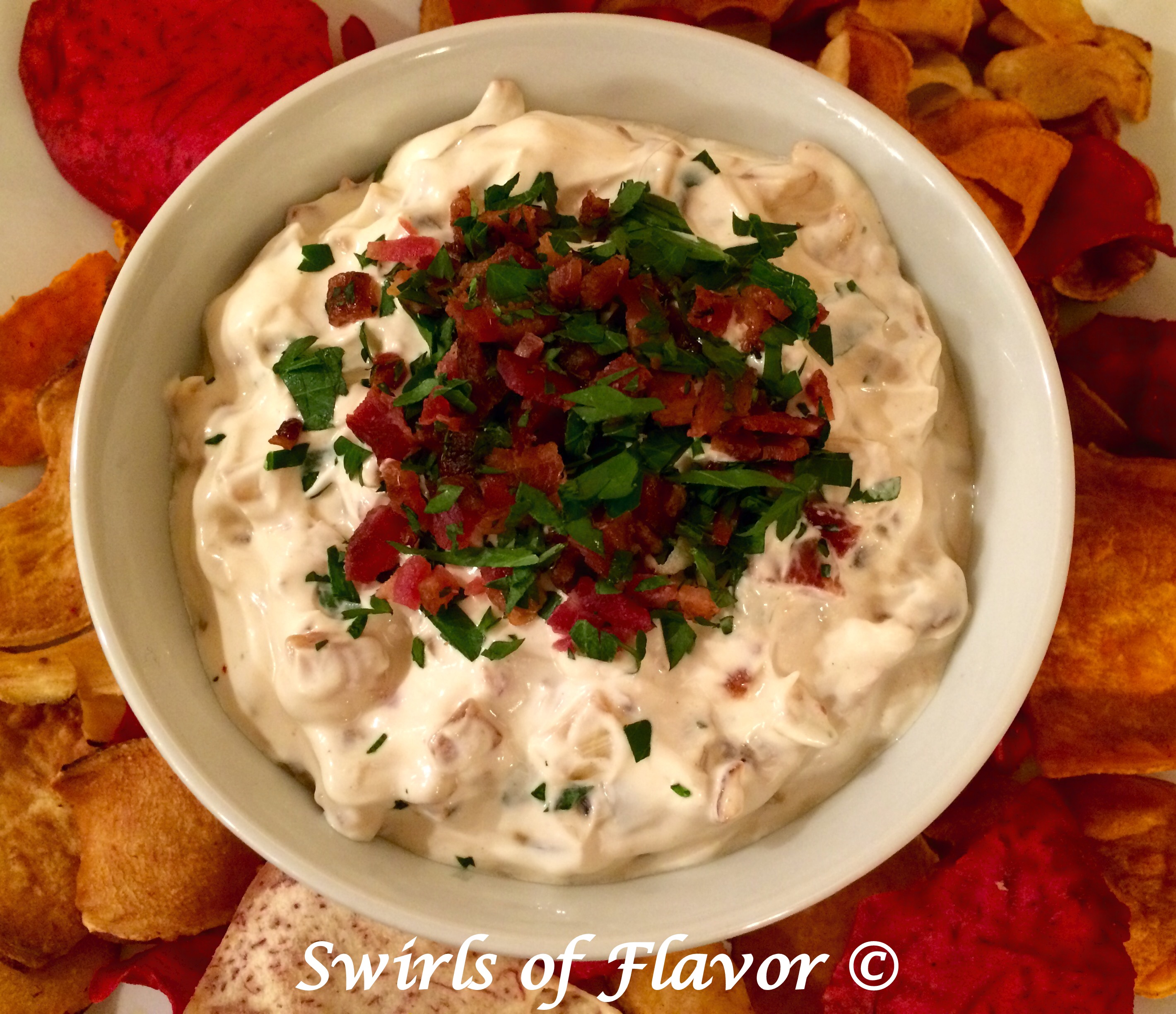 caramelized onion dip with bacon and chips in a round bowl