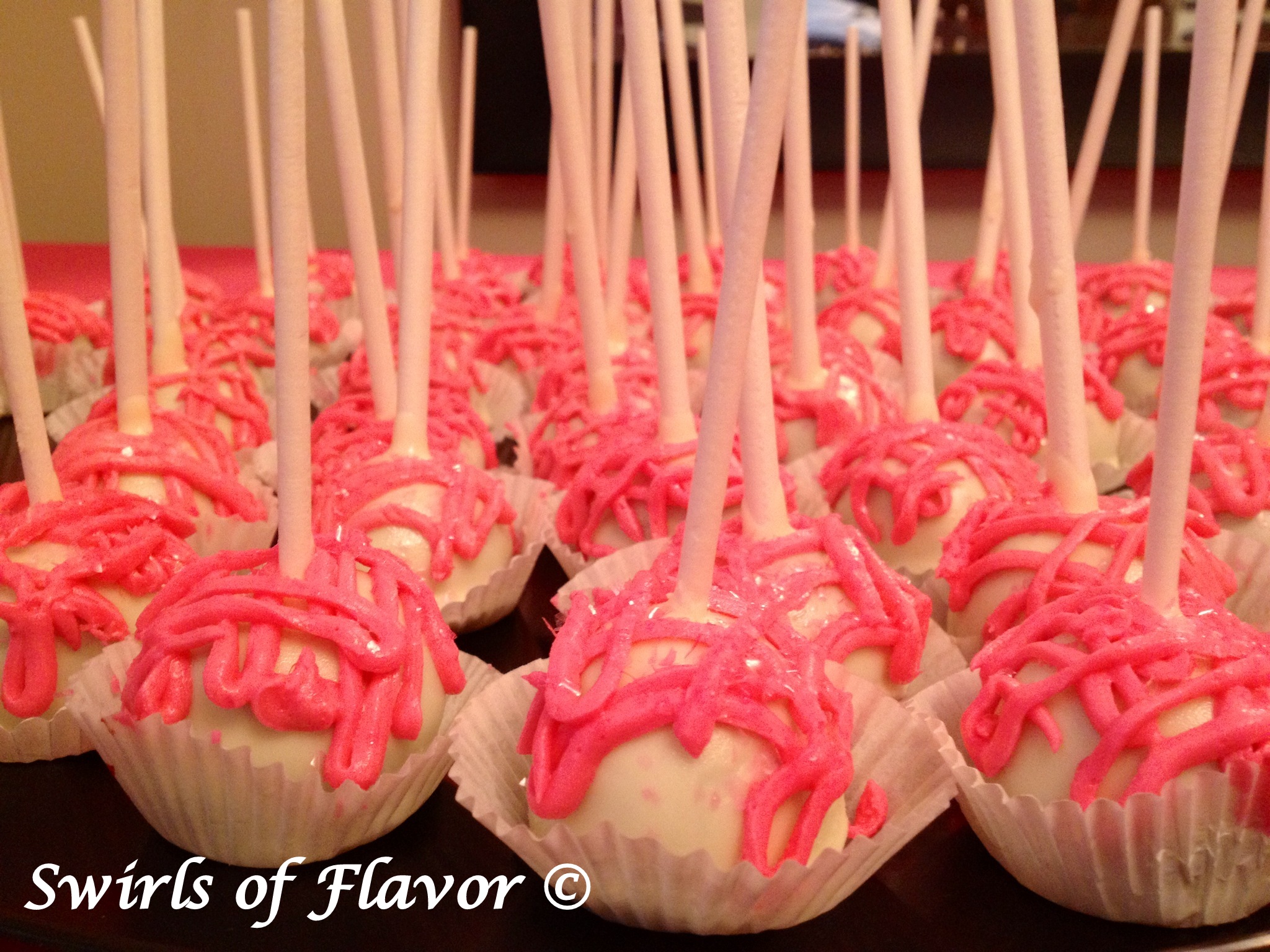vanilla cake pops with pink drizzle