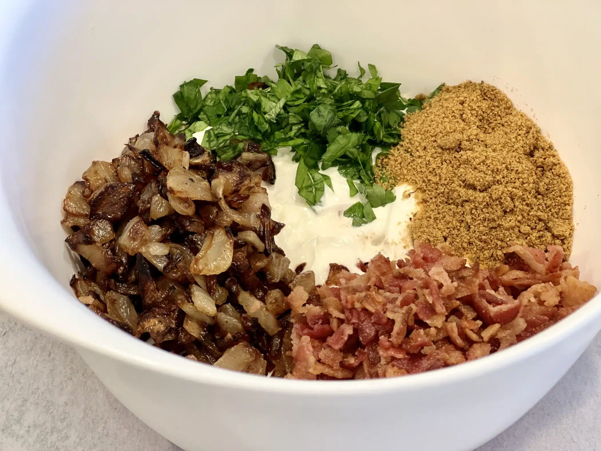 combining ingredients for caramelized onion dip in a mixing bowl