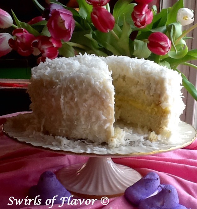 coconut lemon cake on cake stand with slice out