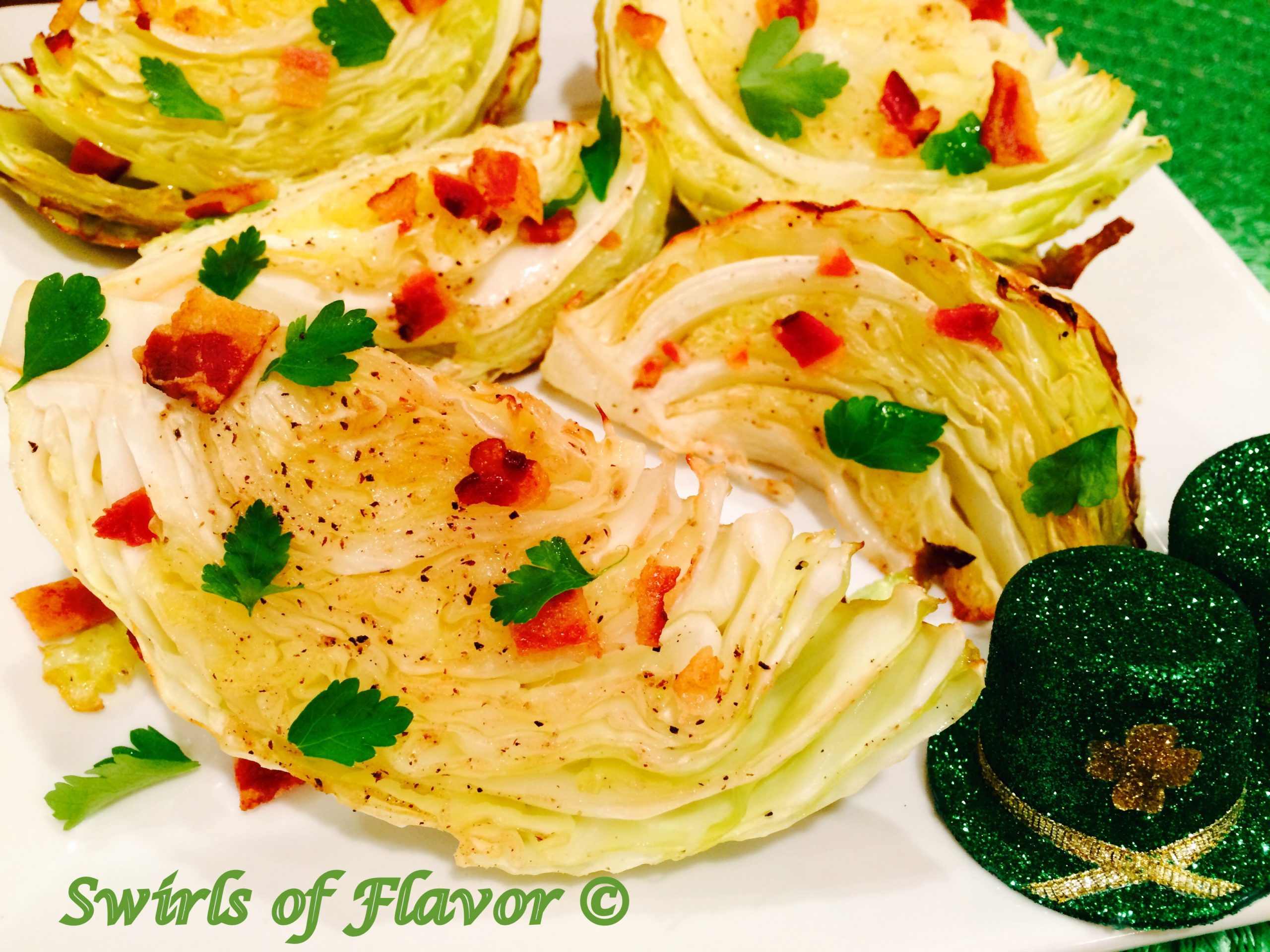 baked cabbage wedges with bacon and parsley on a white dish