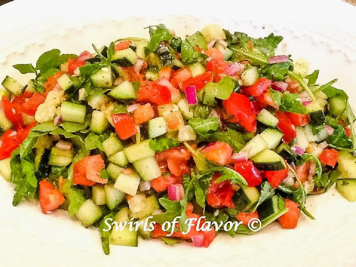 chopped salad with arugula in a white bowl