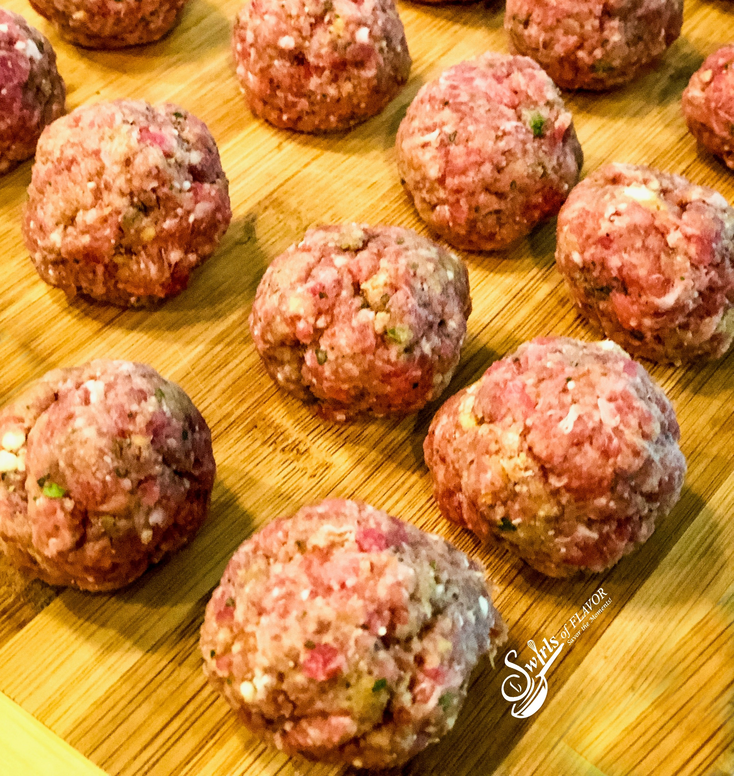 uncooked meatballs on wooden surface