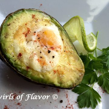 Baked Egg In Avocado combines the perfect protein with a healthy fat creating a powerhouse of nutrition for breakfast! #nationaleggday #easyrecipe #breakfast #avocado #egg #bakedegg #brunch #healthy #worldeggday #swirlsofflavor