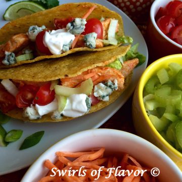 Tacos and buffalo chicken combine to make Buffalo Chicken Tacos! Tortillas are filled with a saucy spicy buffalo chicken topped with celery, carrots, tomatoes and creamy Roquefort blue cheese and combine two favorite foods! An easy recipe for your Taco Tuesday dinner! #tacos #buffalochicken #chicken #TacoTuesday #easyrecipe #familyfavorite #weeknightdinner #swirlsofflavor