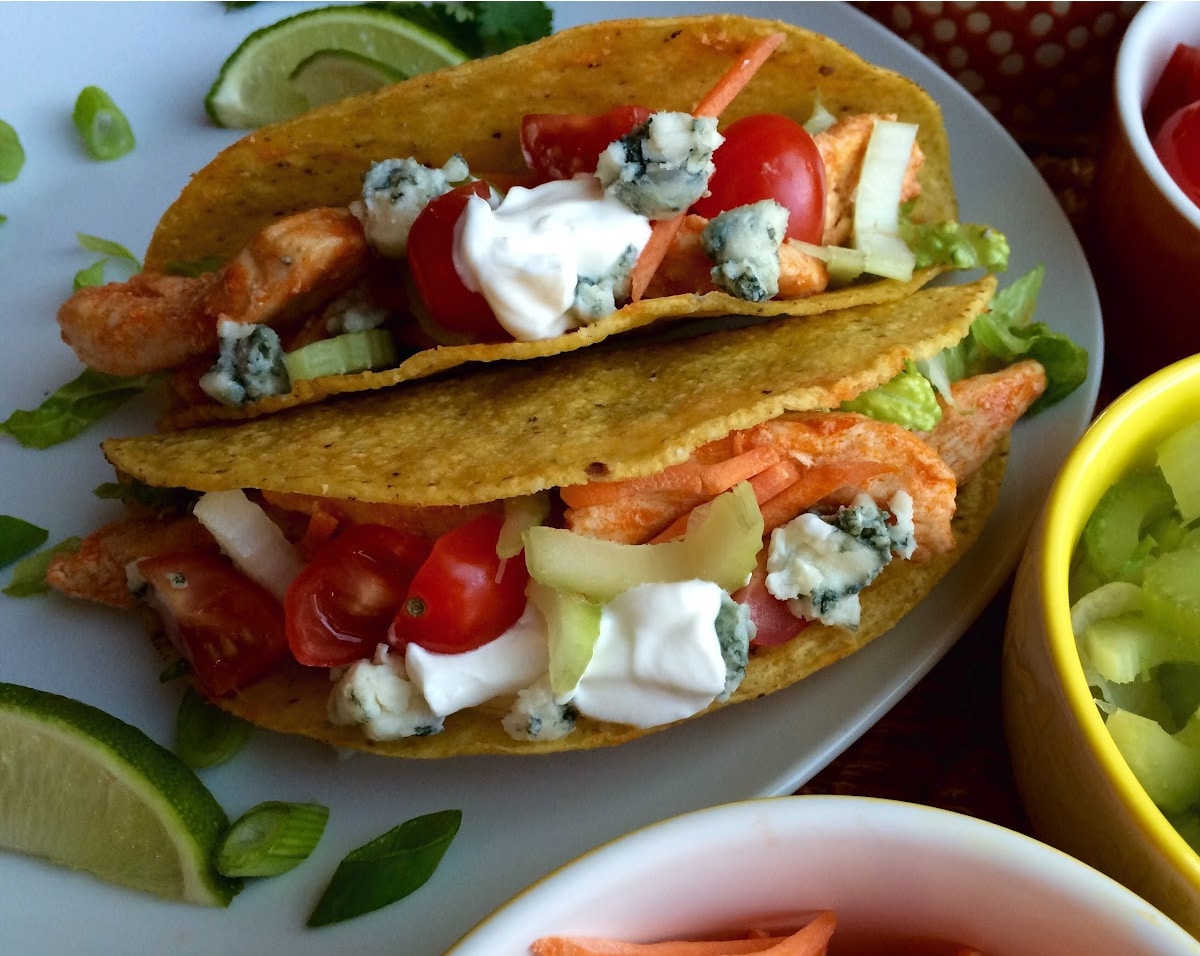 two chicken tacos with buffalo sauce and blue cheese