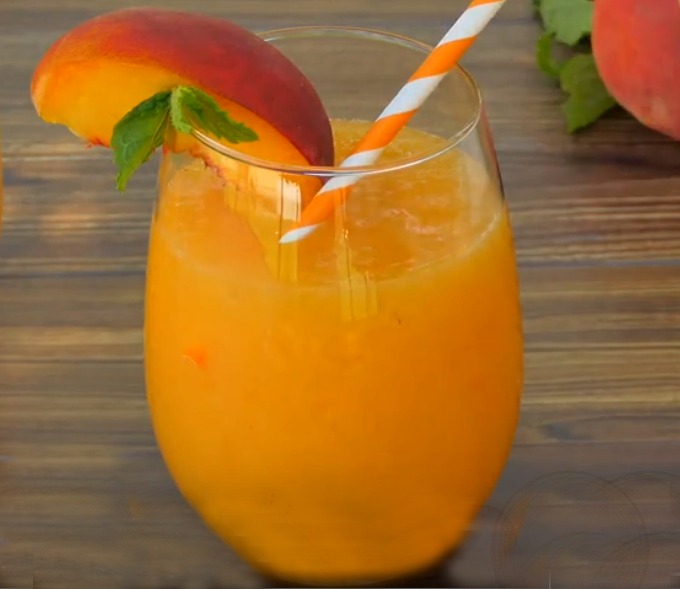 PePeach Bellini Slushy with fresh mint and peach slice garnish and orange and white straw