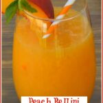 Peach bellini slushy in a stemless wine glass with peach slice and mint and a straw