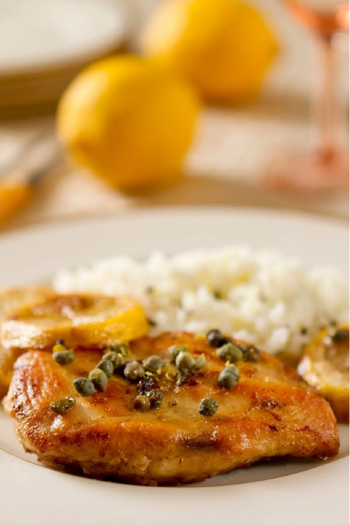 chicken with lemon and capers on a plate with rice