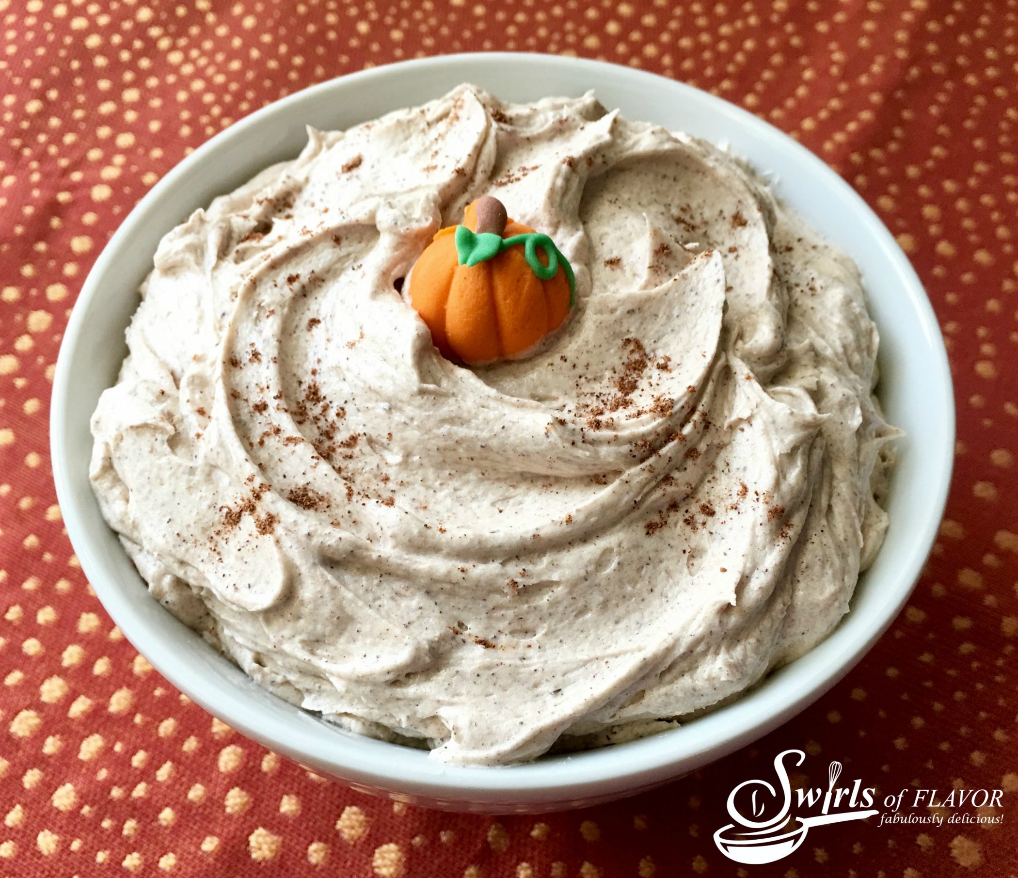 pumpkin frosting in bowl with sugar pumpkin on top