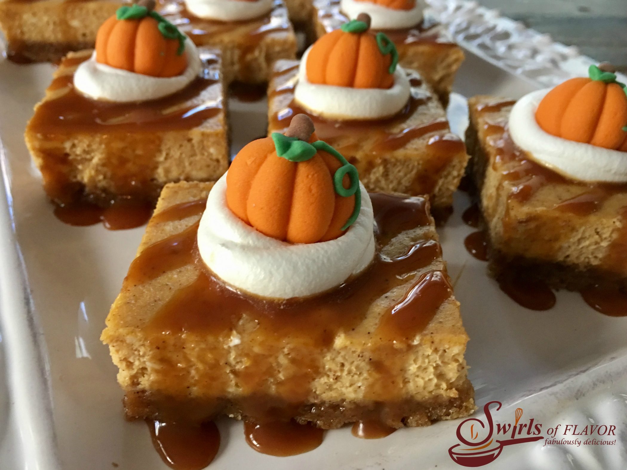 Salted Caramel Pumpkin Spice Cheesecake Bars is an easy way to make a cheesecake recipe without all the fuss. Every bite of these creamy cheesecake bars recipe is kissed by the warm holiday flavor of pumpkin pie spice and buttery cinnamon graham crust! And it's such an easy recipe to make and will impress your guests too! #pumpkinspice #pumpkincheesecake #cheesecakebars #easyrecipe #dessert #easydessert #holiday #saltedcaramel #pumpkincheesecakebars #pumpkinpuree #pumpkinpiespice #swirlsofflavor