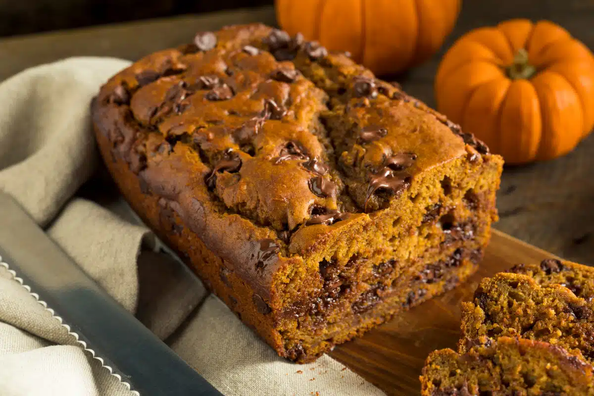 loaf of pumpkin bread on a board with a knife